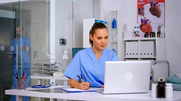 Professionelle Krankenschwester schreibt auf Klemmbrett Patientengesundheitsbericht — Stockfoto