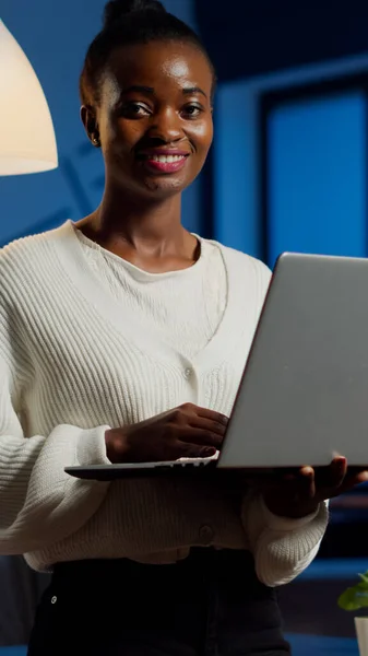 Zwart business vrouw op zoek naar camera glimlachende holding laptop — Stockfoto