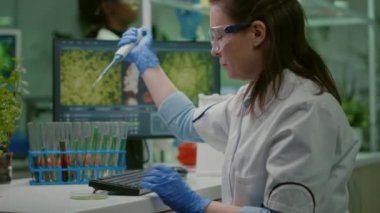 Biyolog araştırmacı mikropipet ve petri kabı kullanıyor.
