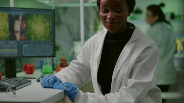 Portrait of biologist researcher woman in white coat looking into camera — Stock Video