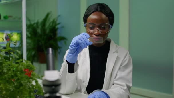 Pesquisador botânico cientista analisando amostra de líquido verde sob microscópio — Vídeo de Stock