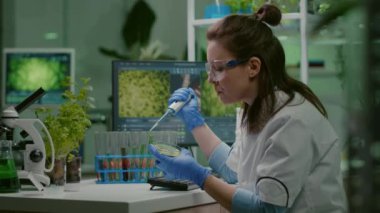 Kimyager kadın test tüpünden mikro pipetle DNA sıvısı alıyor.