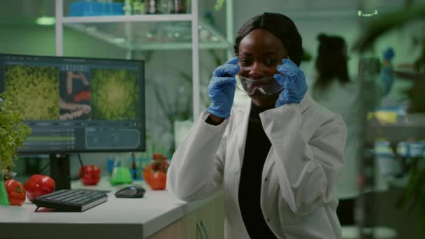 Portret van een Afrikaanse bioloog in witte jas die in de camera kijkt — Stockvideo