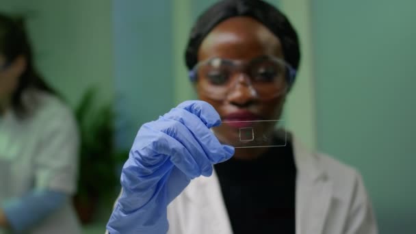 Mujer botánica africana mirando la muestra de prueba genética para el experimento biológico — Vídeos de Stock