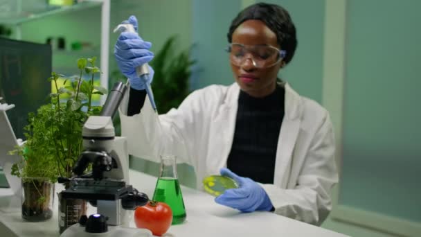 Químico cientista mulher africana tomando solução de dna de tubo de ensaio — Vídeo de Stock