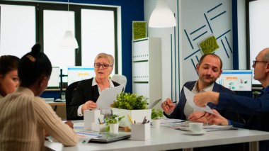 Kadın sekreter idari müdüre belge ve kahve getiriyor.