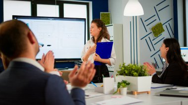 Şirket stratejisini sunan yönetici yönetici, iş dünyası seyircisi alkışlıyor