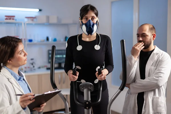 과학 스포츠 연구소에서 마스크를 쓰고 건강 운동을 하는 여자 운동 선수 — 스톡 사진