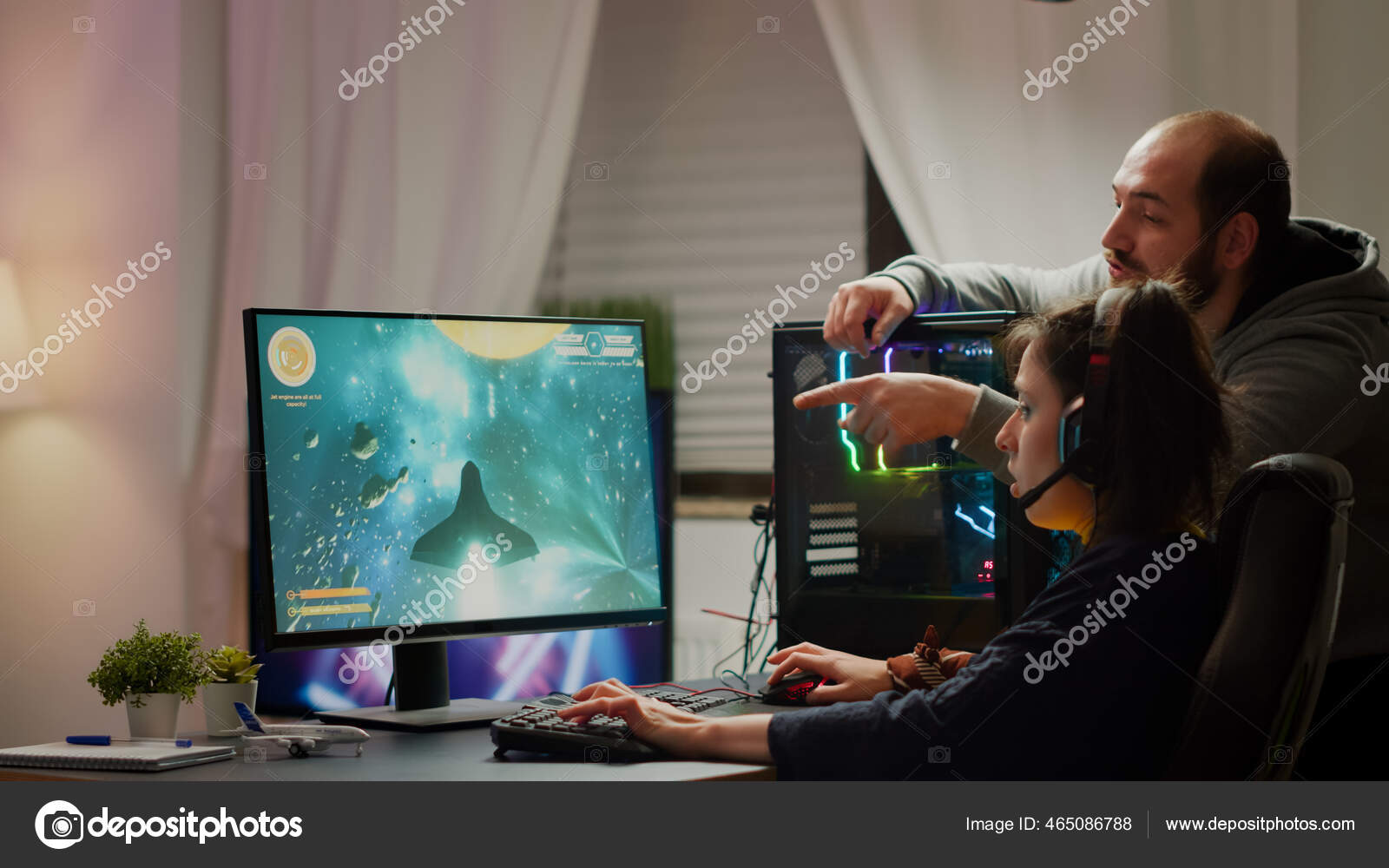 Man gamer teaching his girlfriend playing space shooter video game Stock  Photo by ©DragosCondreaW 465086788