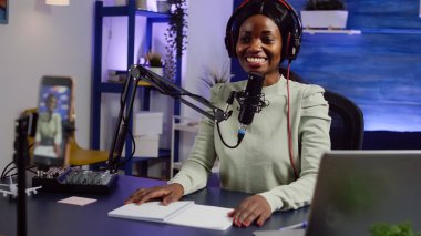 Afrikalı yaratıcı kameraya el sallıyor, gülümsüyor ve izleyicilerle konuşuyor.