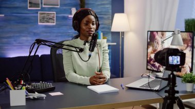 Video kamera kaydedilirken evde oturan siyah blogcu