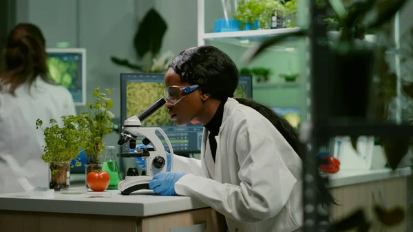 Biologist woman examining biological slide for medical expertise — Stock Photo, Image