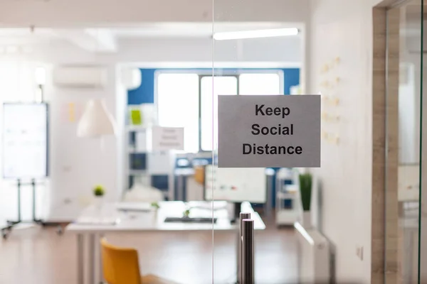 Keep Social Distance sign on glass wall in empty office — Stock Photo, Image