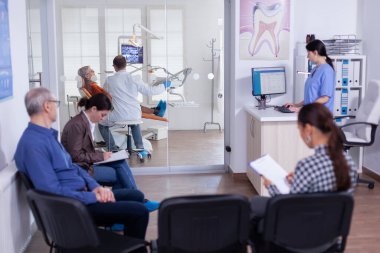 Dişçi doktor stomatoloji kliniğinde dişlerini tedavi ediyor.