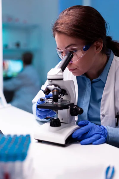 Healthcare scientist looking through microscope in pharmacy lab — Stock Photo, Image