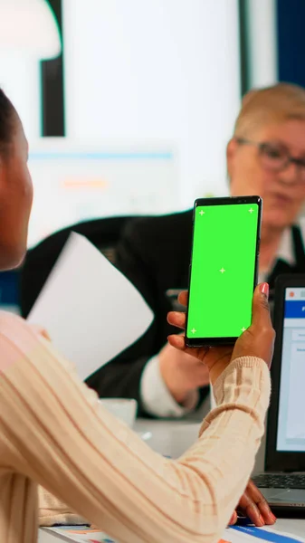 Femme d'affaires noire assise au bureau de conférence tenant smartphone avec écran vert — Photo