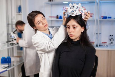 Moden Kliniği 'ndeki nörolog beyin taraması için hasta kulaklığı hazırlıyor.