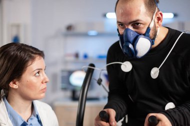 Fen laboratuarındaki sporcu kardiyo performansını test ediyor