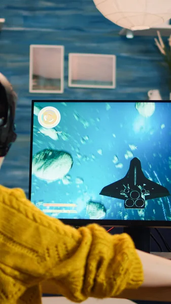 Expert woman gamer playing space shooter video game