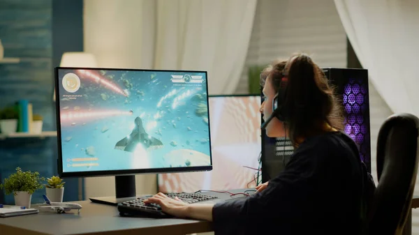 Jugador sentado en la silla de juego jugando juegos de disparos espaciales en línea video juegos — Foto de Stock