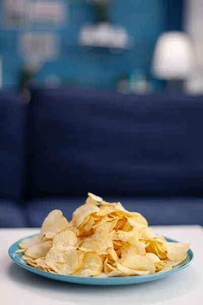 Primer plano de las patatas fritas merienda en la mesa en la sala de estar vacía — Foto de Stock