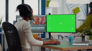 Kulaklıklı film montajı yapan Afrikalı kadın kameraman.