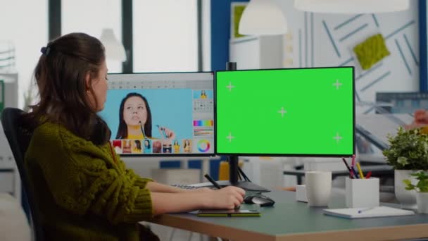 Kvinna retuscher arbetar på foto set med hjälp av grön skärm display — Stockvideo
