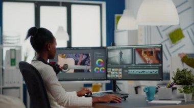 Afrikalı video düzenleyici gülümseyen video projesine bakıyor