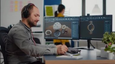 Yeni projede çalışan tasarımcı adam grafik yazılımlı pc kullanıyor