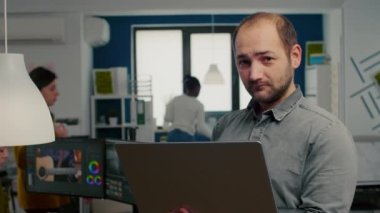 Video düzenleyicisi kameranın önünde gülümsüyor.