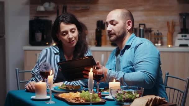 Mari utilisant la tablette pendant le repas festif — Video
