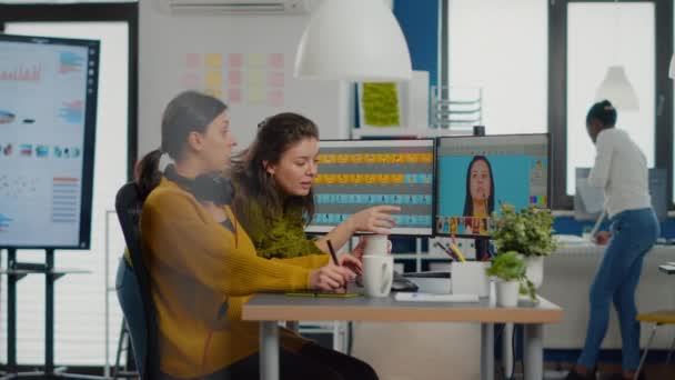 Mujeres confiadas editoras de fotos sentadas en el lugar de trabajo en un estudio creativo — Vídeos de Stock