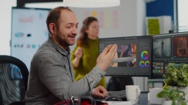 Video düzenleyici elinde akıllı telefon tutarak konuşuyor