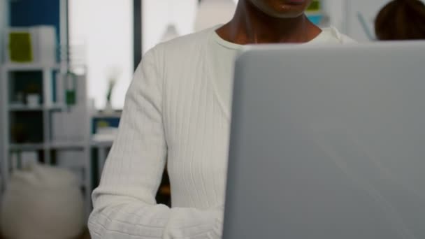 Mujer africana mirando a la cámara sonriendo de pie en la puesta en marcha agencia creativa — Vídeos de Stock