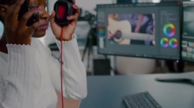 Video görüntülerini düzenleyen kulaklıklı Afrikalı kadın kameraman.