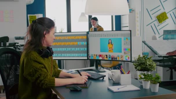 Retoucher nő dolgozik a számítógépen két monitor és ceruza — Stock videók