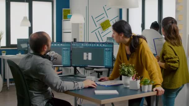 Team av ingenjörer talar framför datorn med CAD-programvara — Stockvideo