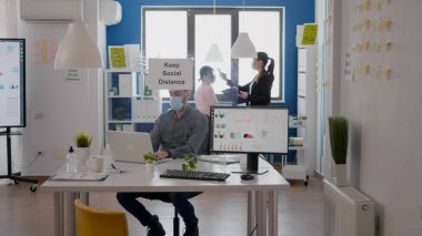 Koruyucu yüz maskesi takan serbest çalışan ekip sıcaklığını tıbbi termometre kullanarak kontrol ediyor.