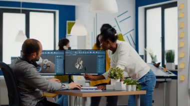 Mekanik parça tasarımında bilgisayar üzerinde çalışan çeşitli mühendisler.