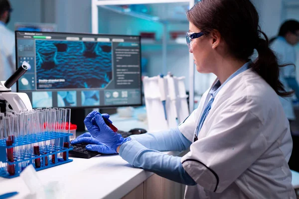Vetenskapsman skriva på bärbar dator som innehar vakutainer blod vård kemi — Stockfoto