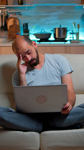 Homme fatigué en pyjama naviguant sur Internet informations sur le mode de vie — Photo