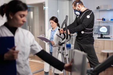 Biyomekanik çalışan sporcu vücuduna ve maskesine yapışmış.
