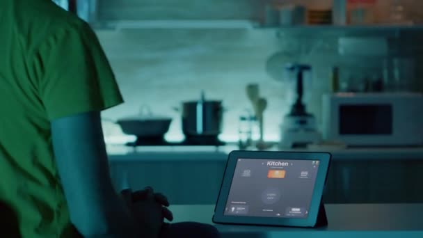 Man kijkt naar tablet met intelligente software geplaatst op keukentafel — Stockvideo