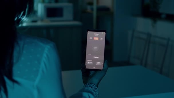 Weibchen halten Smartphone mit Lichtsteuerung — Stockvideo