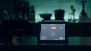 Akıllı yazılımlı tablet mutfaktaki masaya yerleştirilmiş ve kimse yok.