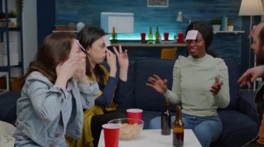 Bir grup çok ırklı insan masa oyunu oynarken eğleniyor