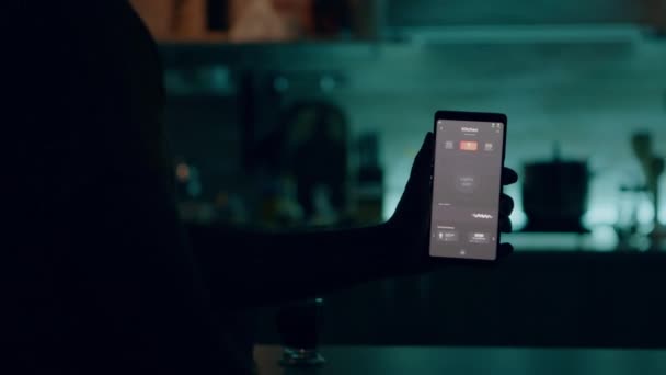 Muž držící smartphone s aplikací pro ovládání osvětlení, rozsvícení světel — Stock video