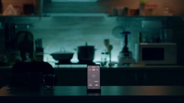 誰もいないキッチンでテーブルの上にインテリジェントなソフトウェアを搭載した電話 — ストック動画