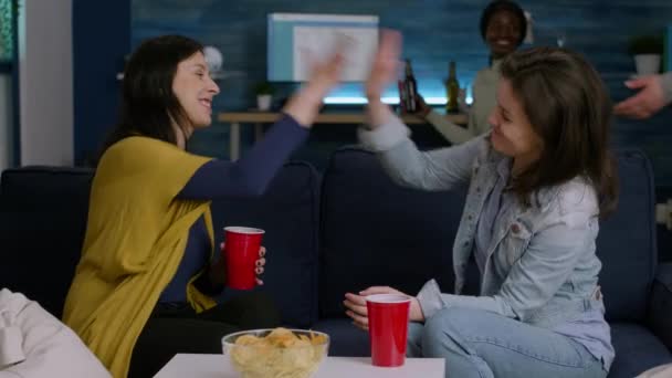 Mulheres felizes desfrutando de amizade com alta cinco tarde da noite na sala de estar — Vídeo de Stock