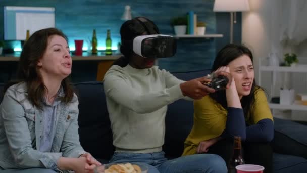 Grupo misto de amigos orientando a mulher afro-americana com fone de ouvido de realidade virtual — Vídeo de Stock